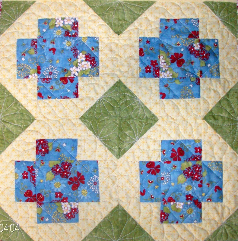 Four quilt squares sewn together of the Greek Cross block.