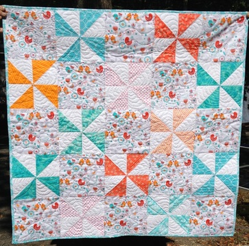 Turquoise and Orange Pinwheel baby quilt from http://www.homesewnbycarolyn.com