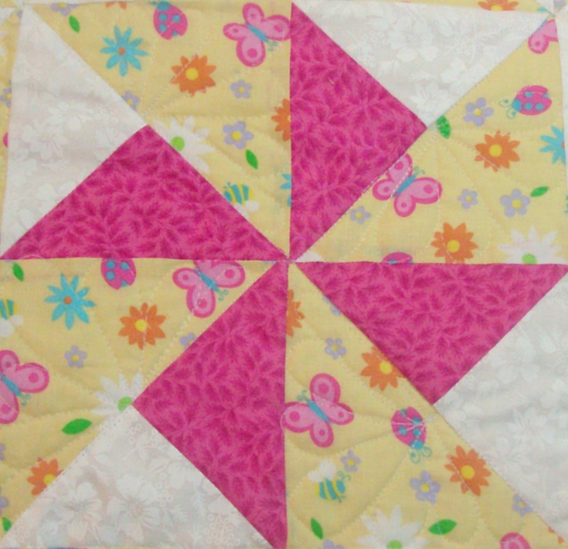 Double Pinwheel quilt block, pink, yellow and white.