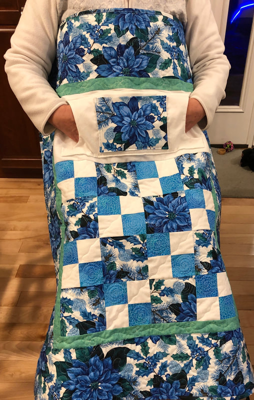 Blue Poinsettia Lovie Lap Quilt with Pockets to keep your hands warm for sale from http://www.HomeSewnByCarolyn.com 