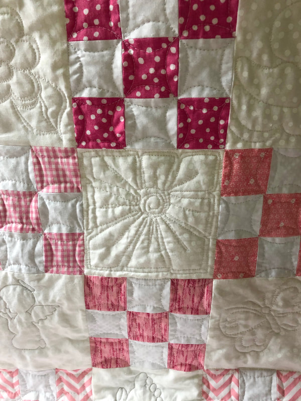 Free motion quilting on nine patch baby quilt from http://www.HomeSewnByCarolyn.com/baby-quilts.html
