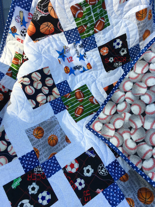 Baseball, soccer, football and basket ball on this adorable baby quilt from http://www.HomeSewnByCarolyn.com