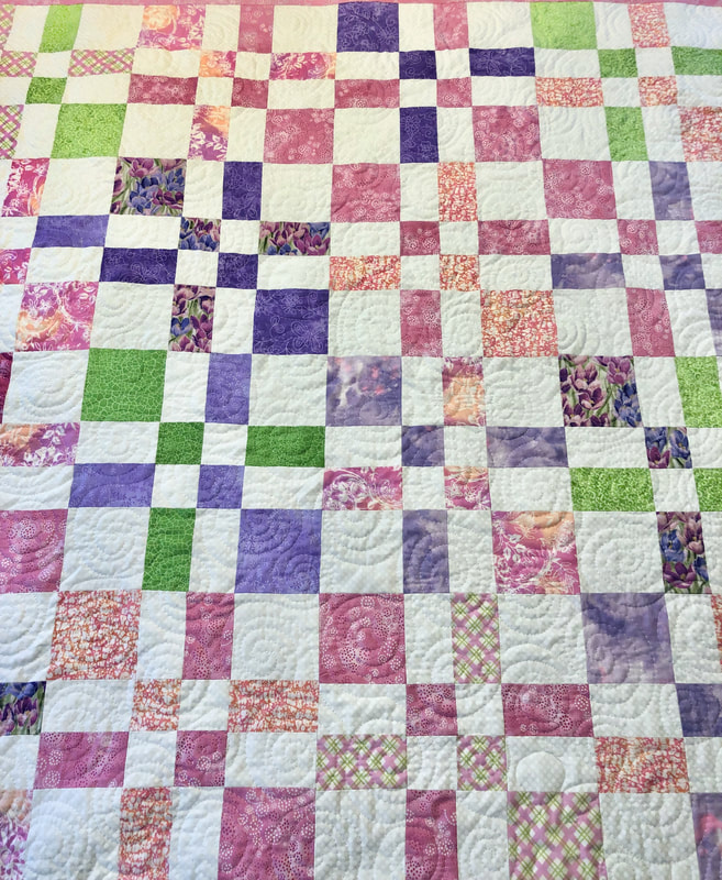 Disappearing Four Patch Baby Quilt in Pink, Green and Purple.