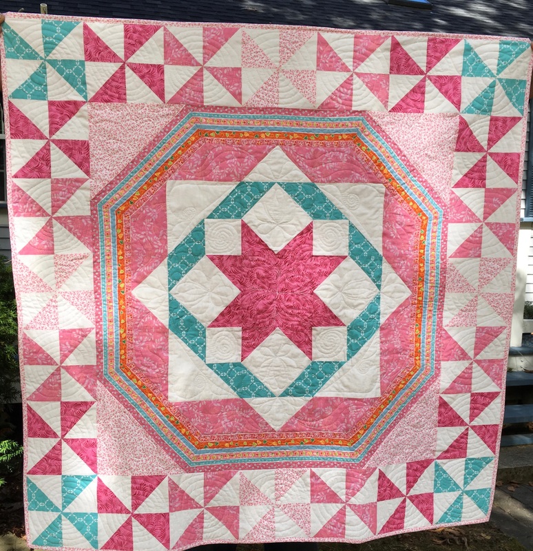 Pink and Teal pinwheel baby quilt from http://www.HomeSewnByCarolyn.com